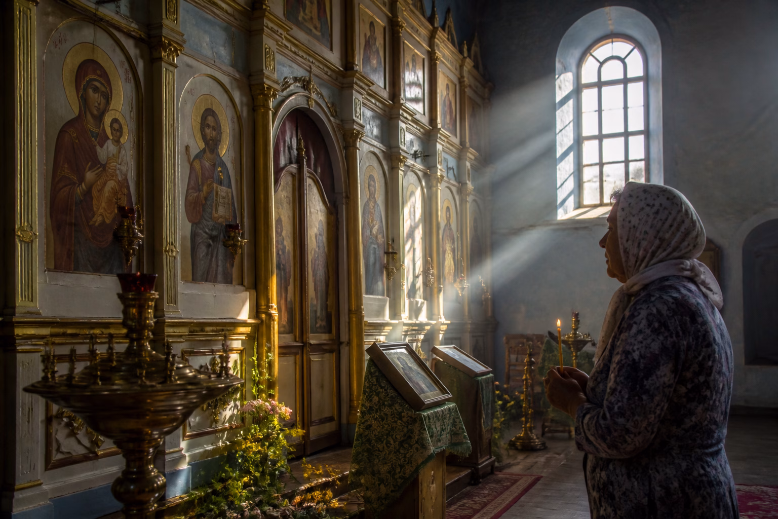 Сільська церква з іконами та жінкою, що молиться, символізує шанування святих Анн