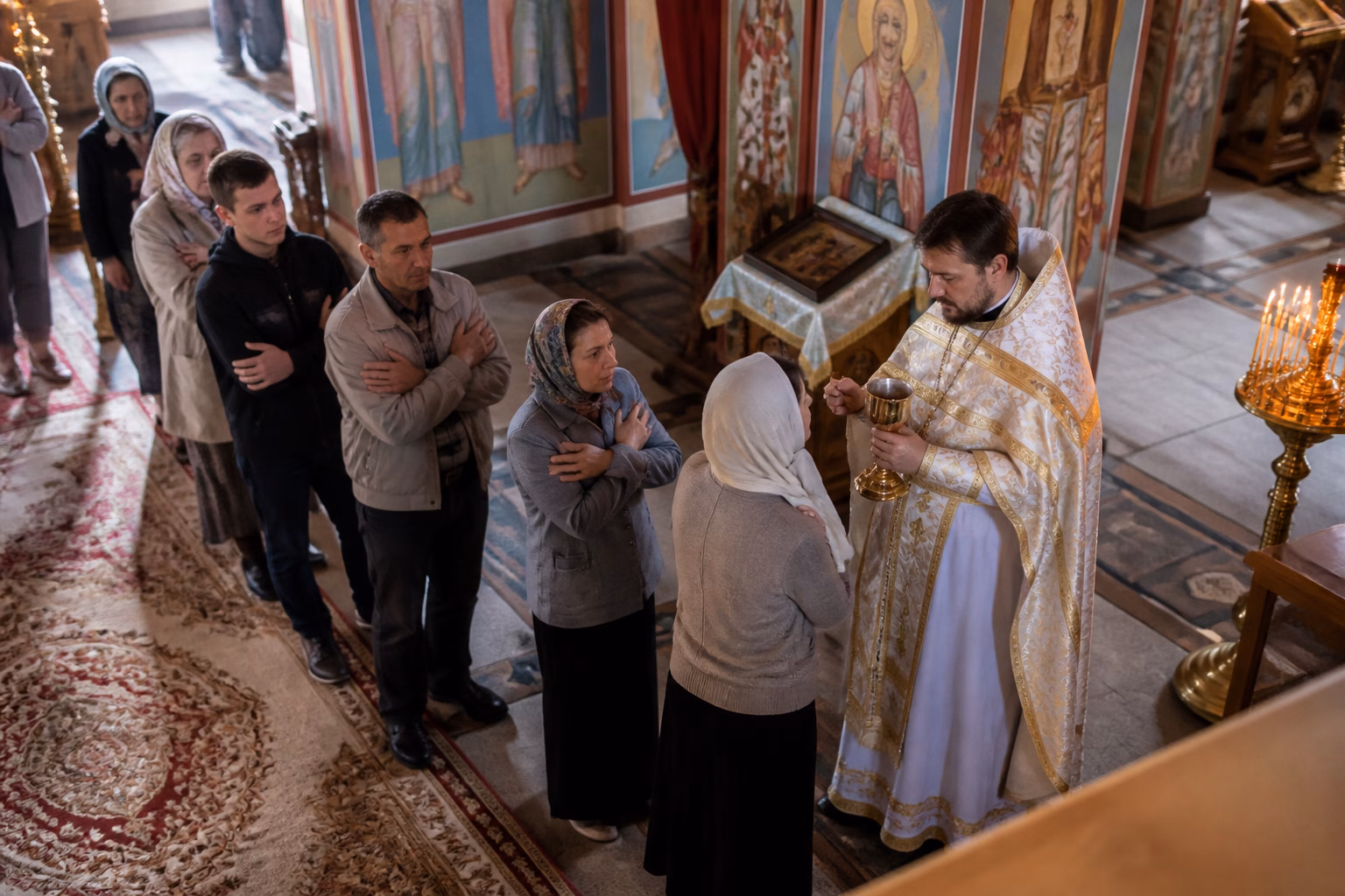 Віряни зі схрещеними руками підходять до Чаші під час літургії