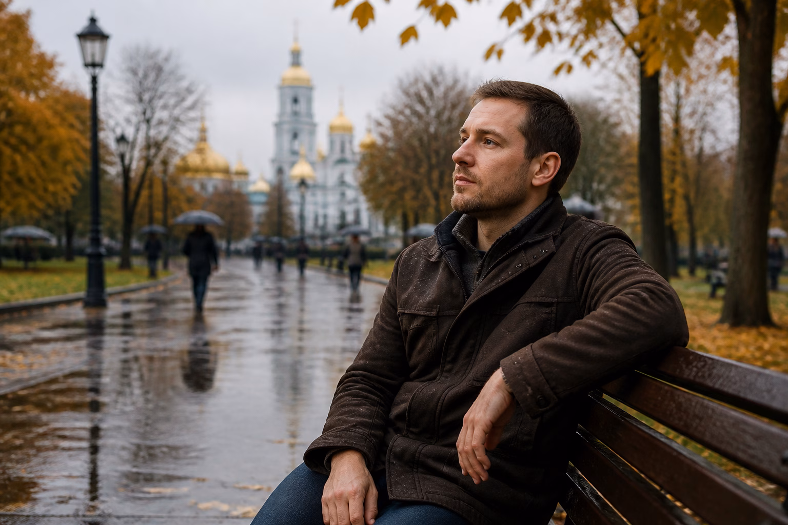 Чоловік на ім'я Сергій замислено сидить на лавці в осінньому парку