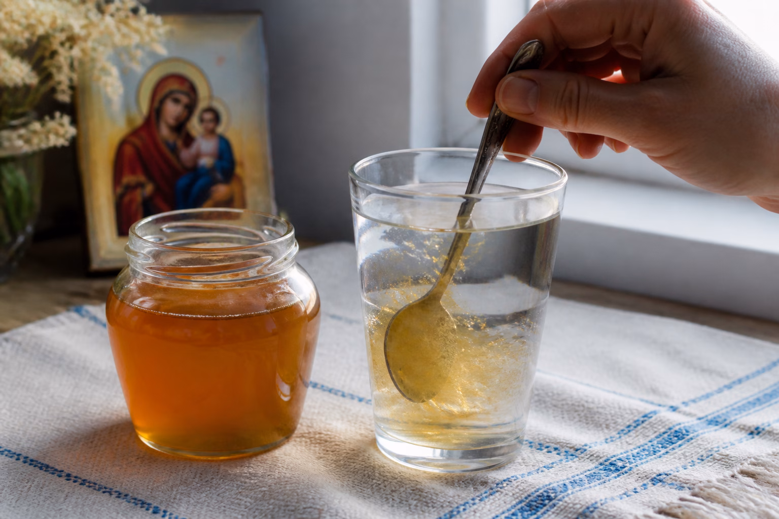Склянка святої води з медом на столі