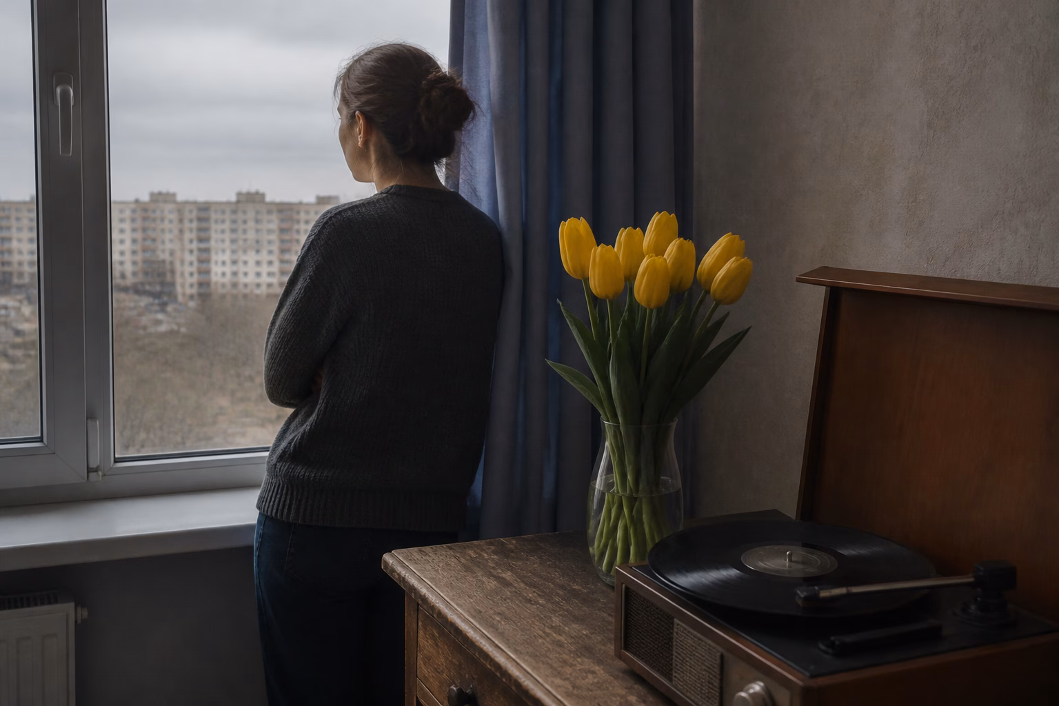 Вініловий програвач із платівкою та ваза з жовтими тюльпанами у вінтажному стилі